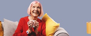 Lady on sofa wearing a personal alarm on her wrist