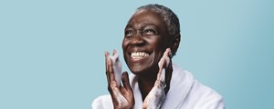 Lady in bath robe washing her face