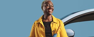 Lady with umbrella leaning on a blue car