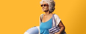 Woman in sunglasses carrying beach bag and rubber ring