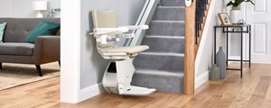 1100 model stairlift shown at the foot of a staircase