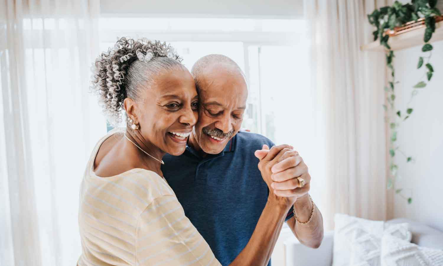 Two senior people dancing in a room
