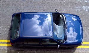 Blue car illegally parked on double yellow lines