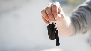 an extended hand holding car keys