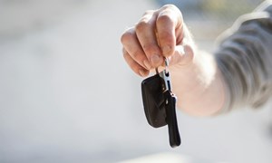 an extended hand holding car keys