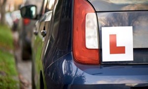 L plate on the back of a blue car
