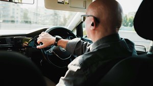 a picture of an older driver behind the wheel of a car
