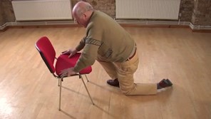 Man getting up from floor using a chair