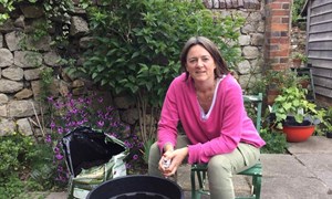 gardening expert alex mitchell sits down in front of a compost barrel