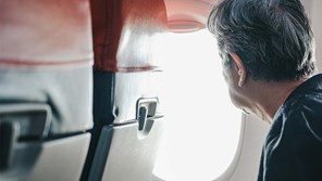 a person with grey hair looking out of an aeroplane window